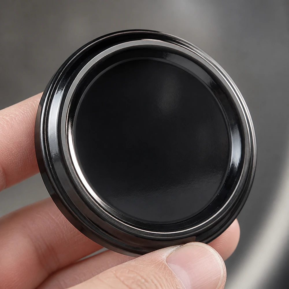 UNiTWIST TO48 czarny BioSeal BPA-NI – zbliżenie na błyszczącą powierzchnię czarnej nakrętki typu twist-off o średnicy 48 mm