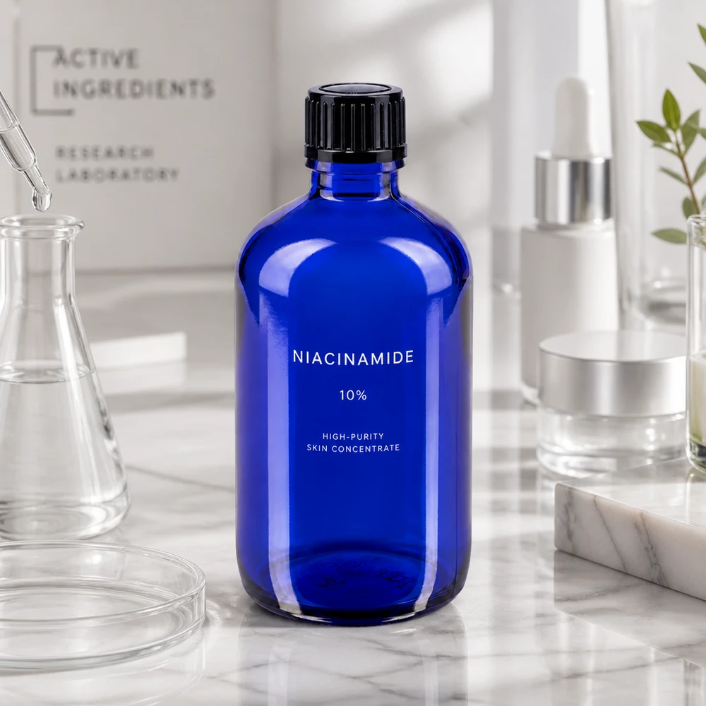 Butelka apteczna niebieska 100ml kroplówka v. 1mm czarny szt Kobaltowo-niebieska butelka apteczna o pojemności 100 ml z etykietą zawierającą niacynamid, na marmurowym tle w otoczeniu laboratoryjnym