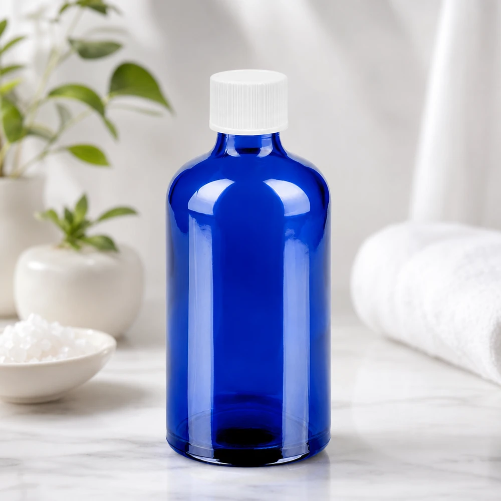 Kompaktowa szklana butelka 100 ml w jasnoniebieskim kolorze z białą nakrętką 11 mm do codziennego użytku