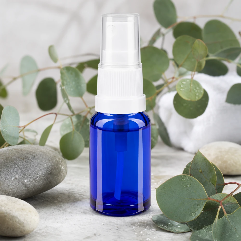Butelka apteczna niebieska 10ml spray top biały 10 ml buteleczka z kobaltowo-niebieskiego szkła aptecznego z białą głowicą rozpylającą, otoczona gałązkami eukaliptusa