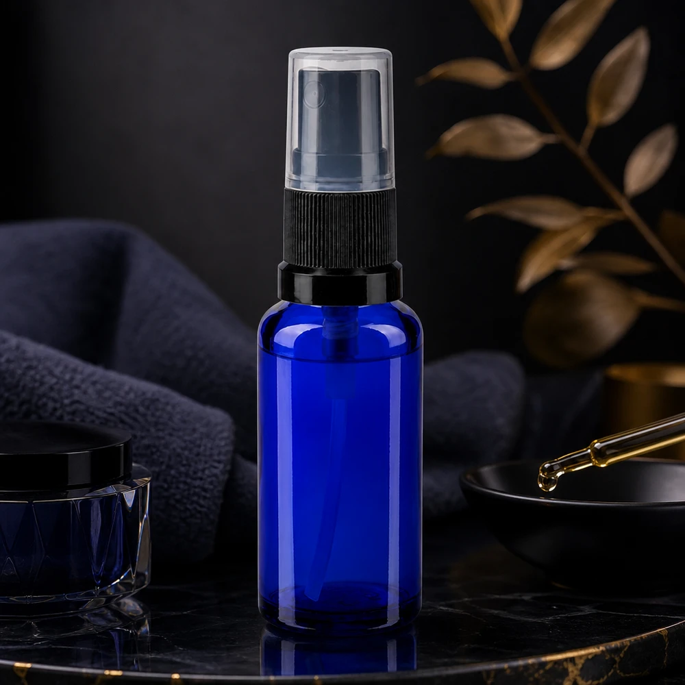 Butelka apteczna niebieska 30ml nasadka rozpylająca czarna Elegancka butelka aptekarska z atomizerem o pojemności 30 ml w kolorze kobaltowym z czarnym atomizerem na ciemnym marmurowym tle