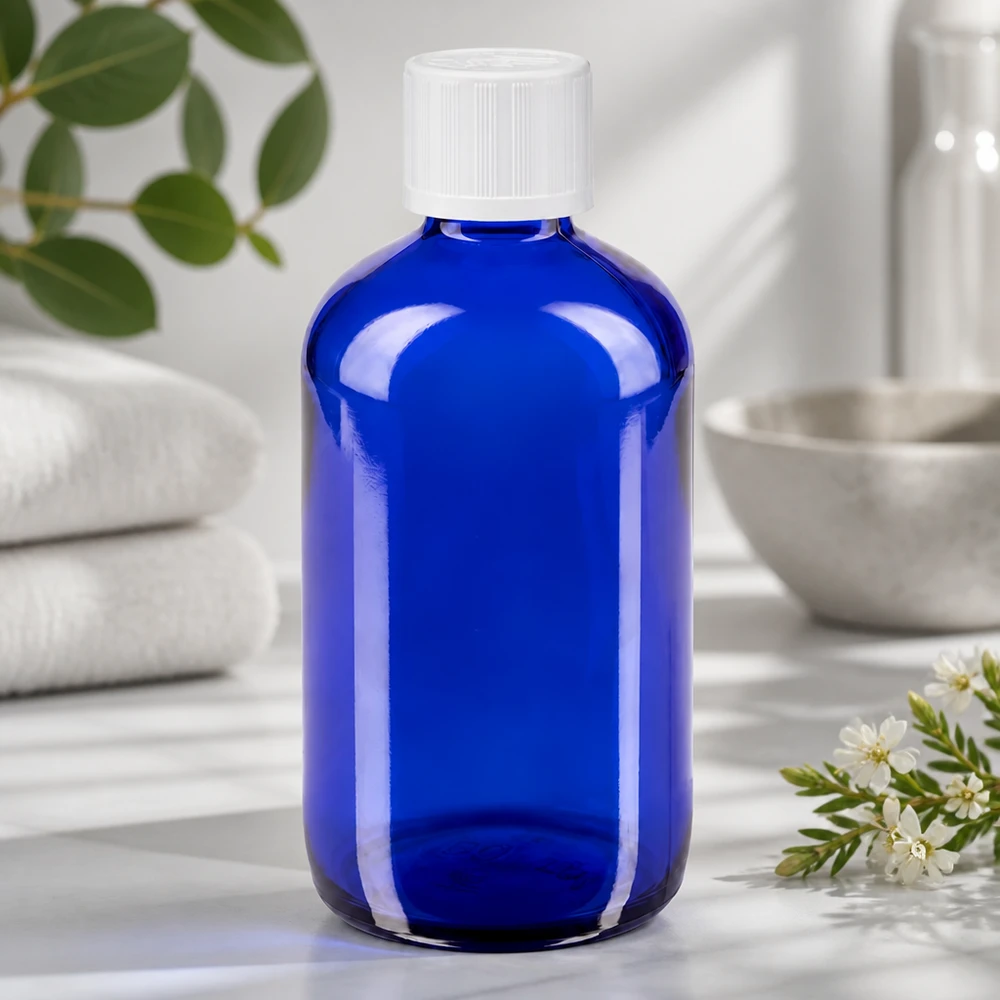 Przezroczysta niebieska szklana butelka o pojemności 100 ml z białą nakrętką zabezpieczającą przed dziećmi i kroplomierzem 1,2 mm