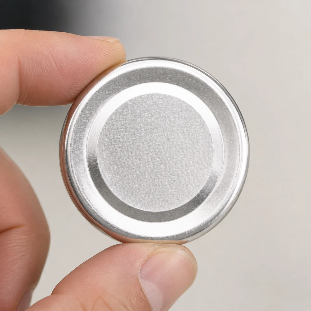 Pokrywka BasicSeal 43 mm, srebrna (TO43) UNiTWIST Zbliżenie na pokrywkę 43 mm TO43 BasicSeal w kolorze srebrnym z systemem UNiTWIST i koncentrycznymi pierścieniami