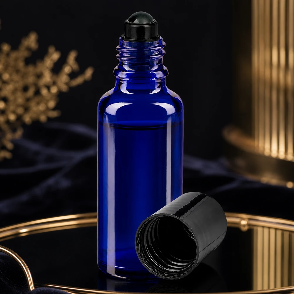 Butelka apteczna niebieska 30ml zakrętka roll-on czarna Niebieska buteleczka z kulką o pojemności 30 ml z otwartą czarną zakrętką na złotej tacy