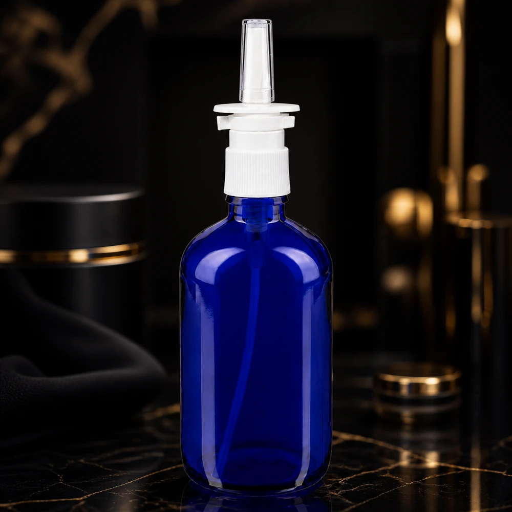 Butelka na spray do nosa o pojemności 100 ml, z niebieskiego szkła, z białą pompką dozującą i przezroczystą plastikową dyszą