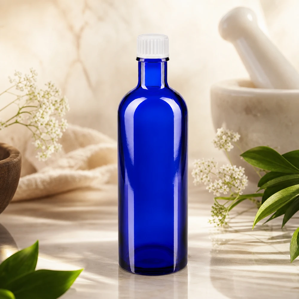 Butelka apteczna niebieska 200ml zakrętka biała szt. Niebieska butelka apteczna o pojemności 200 ml z białą zakrętką, umieszczona wśród ziół leczniczych i moździerza