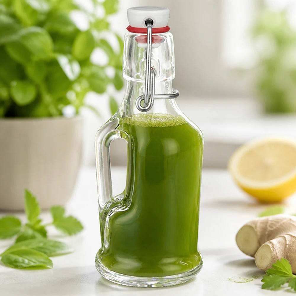 Szklana butelka 200 ml Bertha i porcelanowy zamknięcie zatrzaskowe UNiTWIST® Szklana butelka Bertha 200ml wypełniona zielonym smoothie obok imbiru i cytryny Scena kuchenna UNiTW zatyczka wahadłowa