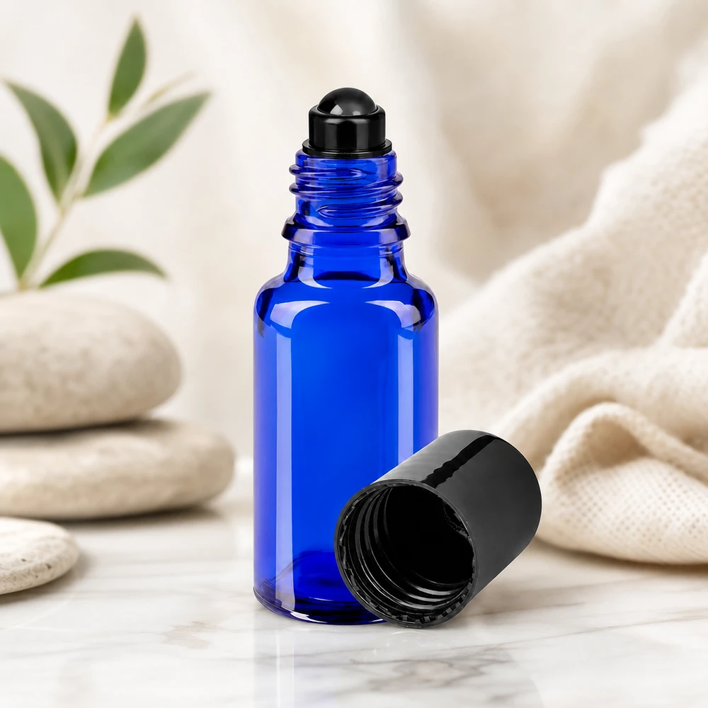 Butelka apteczna niebieska 20ml zakrętka roll-on czarna Niebieska szklana buteleczka apteczna typu roll-on o pojemności 20 ml, model STD, z czarnym aplikatorem kulkowym, otwarta