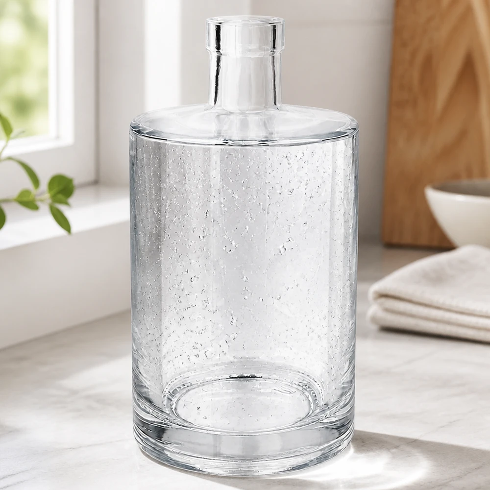 Szklana butelka Marie 700 ml bez zamknięcia UNiTWIST® Elegante 700ml Glasflasche Marie mit Luftbläschen-Optik in modernem Wohnambiente neben Handtüchern und Holzschale