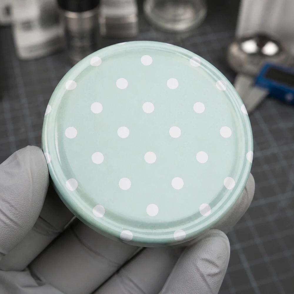 63mm BasicSeal Deckel Punkte mint matt (TO63) UNiTWIST Miętowo-zielona nakrętka BasicSeal 63 mm z białymi kropkami – widok z góry na stół kuchenny