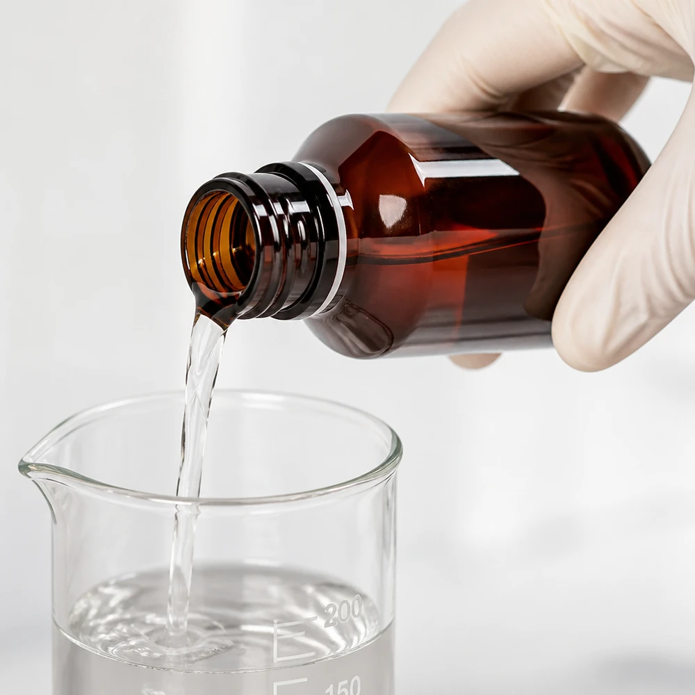 Przezroczysty płyn przelewa się z bursztynowej butelki PET o pojemności 50 ml do zlewki