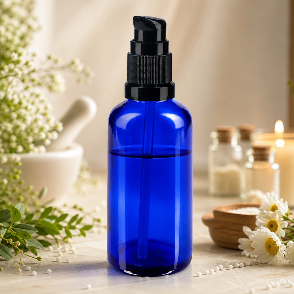 Niebieska szklana butelka apteczna z pompką o pojemności 50 ml, z czarną głowicą dozującą, przeznaczona do produktów kosmetycznych