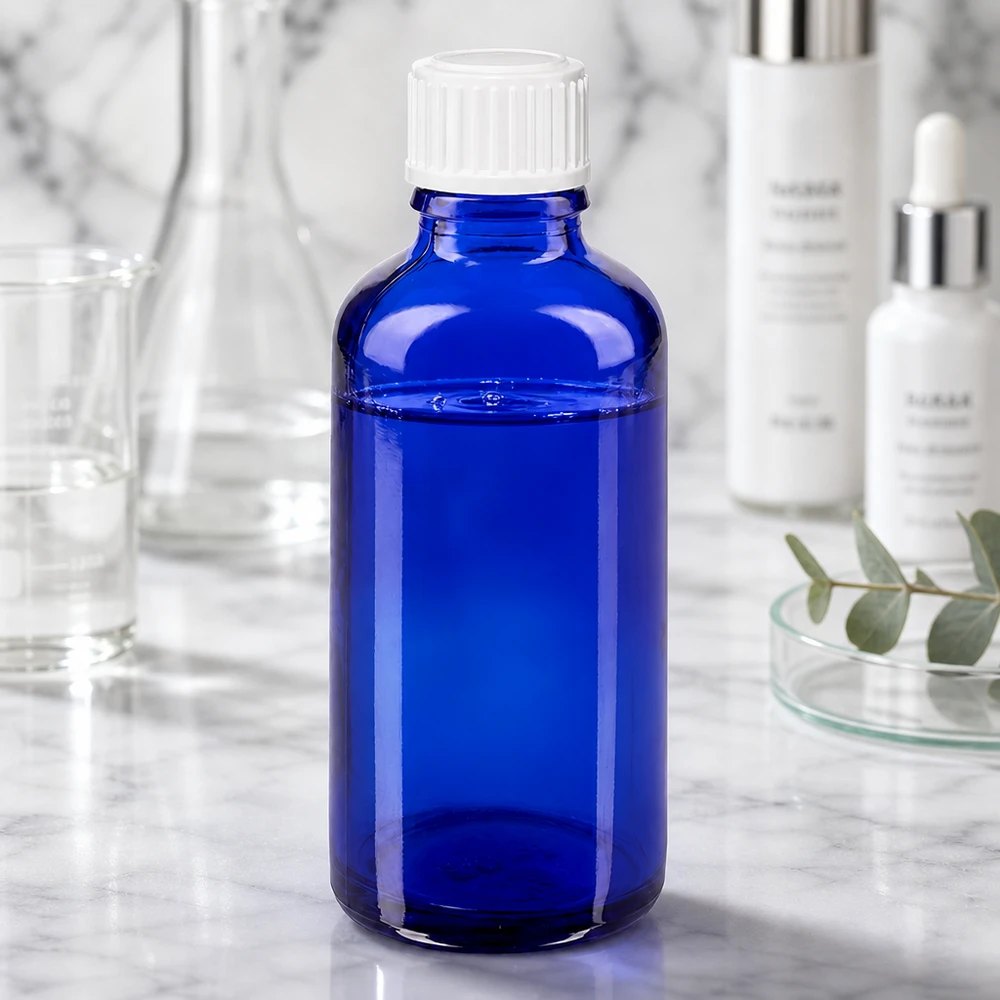 Niebieska buteleczka z zakraplaczem ApoGlas o pojemności 50 ml z białą nakrętką, znajdująca się pomiędzy sprzętem laboratoryjnym a produktami kosmetycznymi