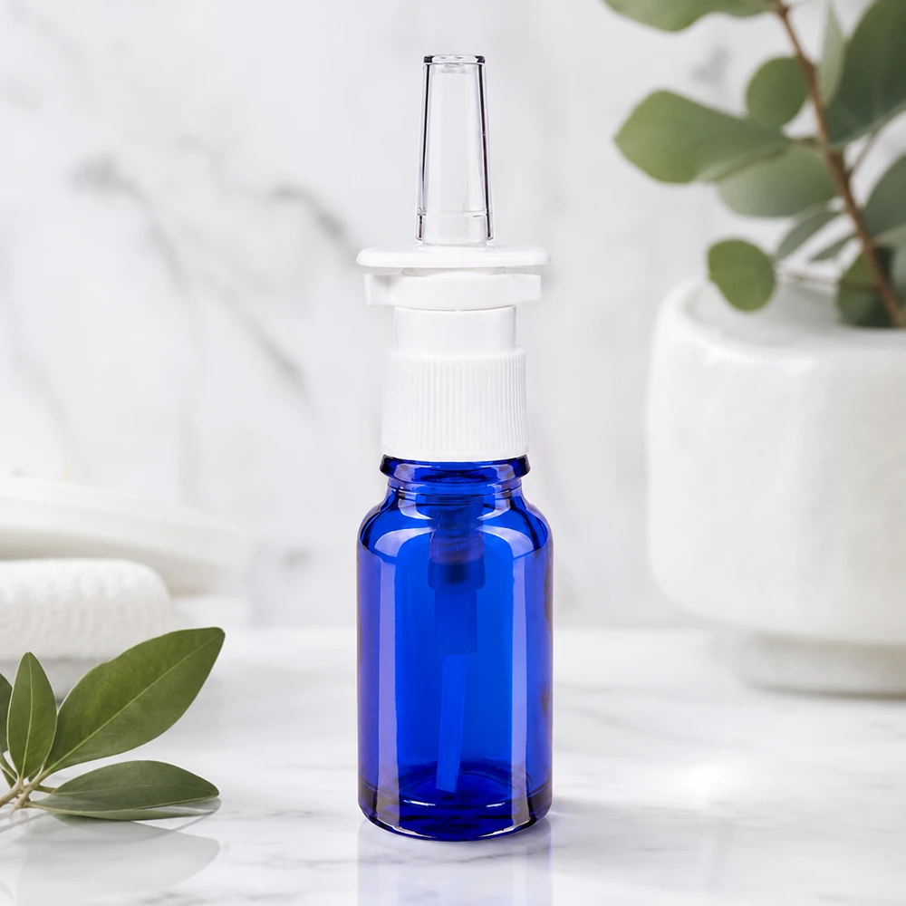 Szklana buteleczka o pojemności 10 ml w kolorze kobaltowym z ergonomiczną białą nasadką z pompką do aerozolu do nosa