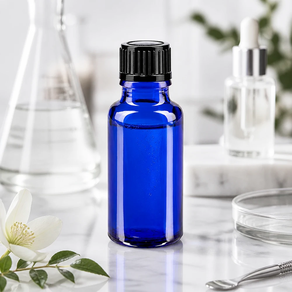 Butelka apteczna niebieska 20ml drip v. 1mm czarny szt Szklana butelka o pojemności 20 ml w kolorze kobaltowym z czarnym zamknięciem zabezpieczającym przed dziećmi na tle marmuru