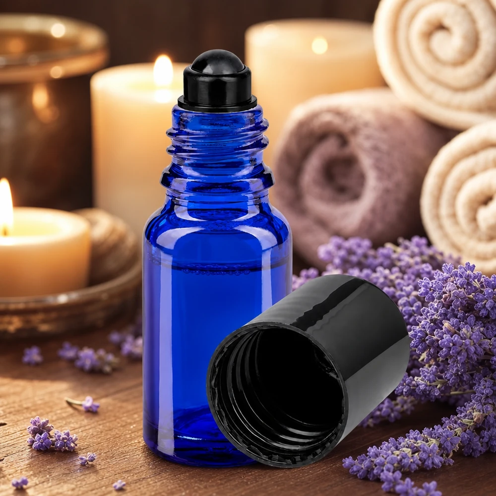 Niebieska buteleczka ApoGlas z kulką o pojemności 10 ml z lawendą oraz świece w relaksującej atmosferze spa