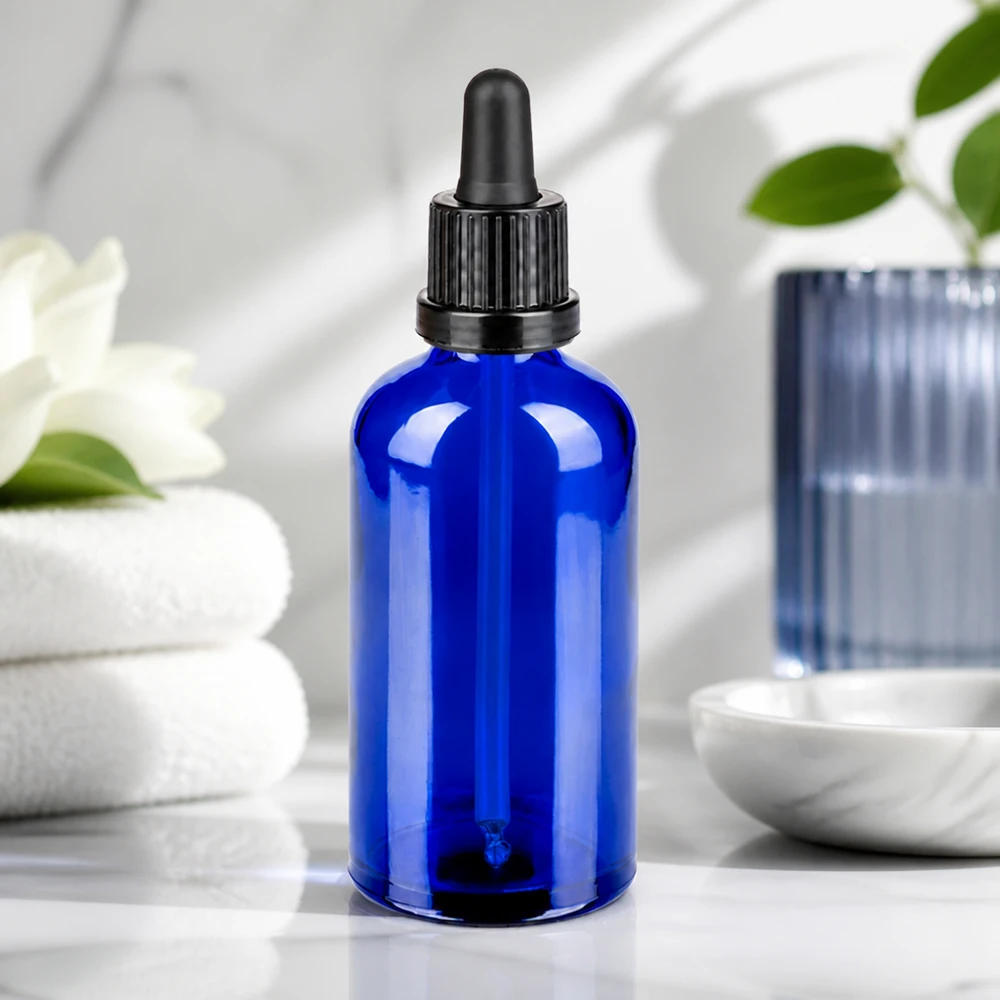 Elegancka niebieska szklana butelka 100 ml z czarną pipetą do stylowej prezentacji produktu