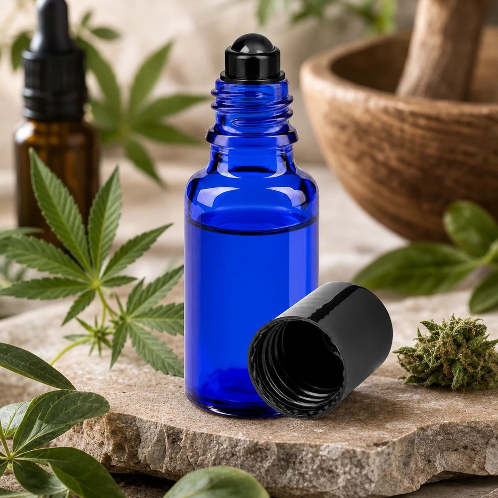 Mała buteleczka z kulką o pojemności 20 ml, wykonana z niebieskiego szkła aptecznego, obok rośliny konopi i moździerza