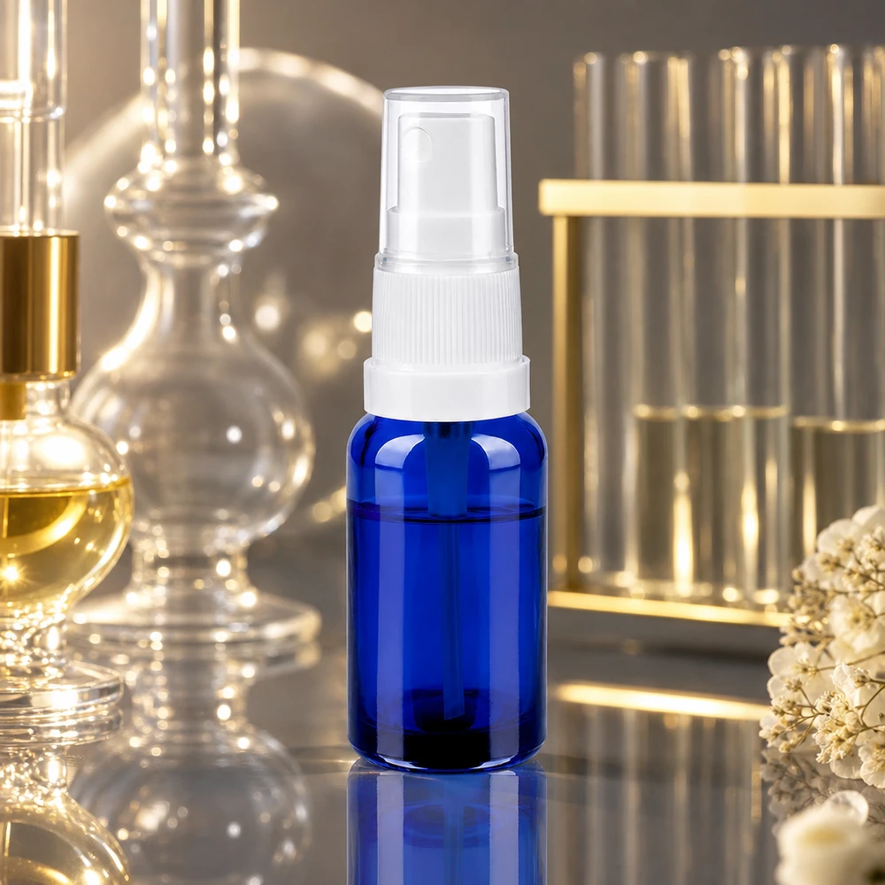 Butelka ze spryskiwaczem 20 ml biała/przezroczysta STD BlueLine UT18/20 Kompaktowa butelka z rozpylaczem o pojemności 20 ml wykonana z wysokiej jakości niebieskiego szkła z ergonomiczną białą nasadką rozpylającą