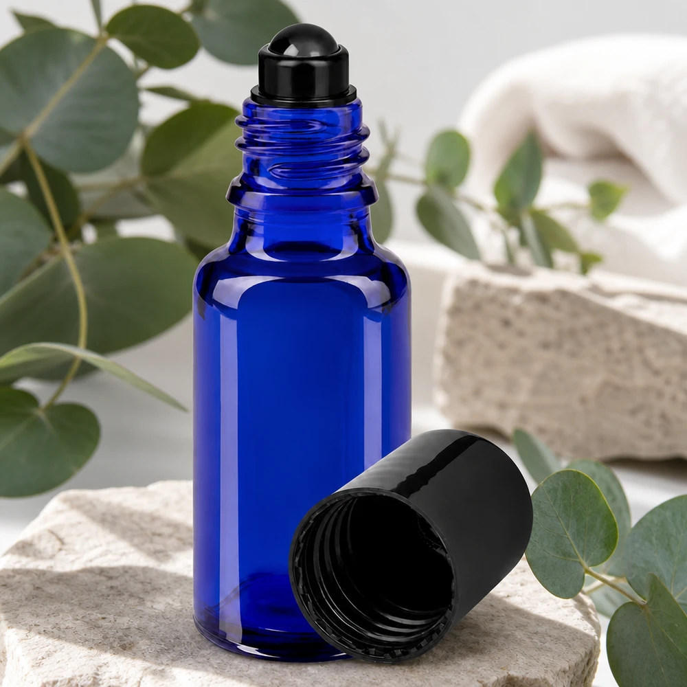 Niebieska szklana buteleczka apteczna typu roll-on o pojemności 20 ml z czarną kulką i otwartą pokrywką