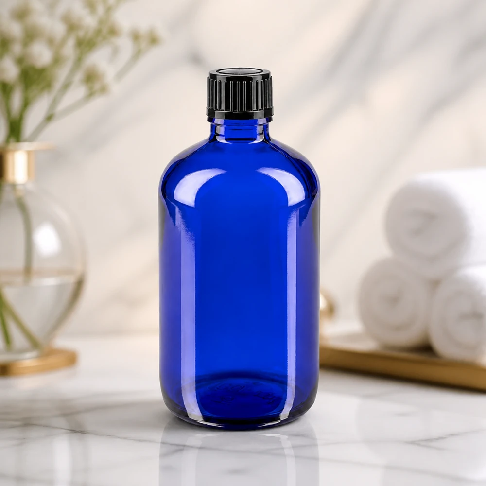 Butelka apteczna niebieska 100ml zakrętka czarna szt. Cylindryczna niebieska butelka szklana o pojemności 100 ml z żebrowaną czarną zakrętką na marmurowym tle