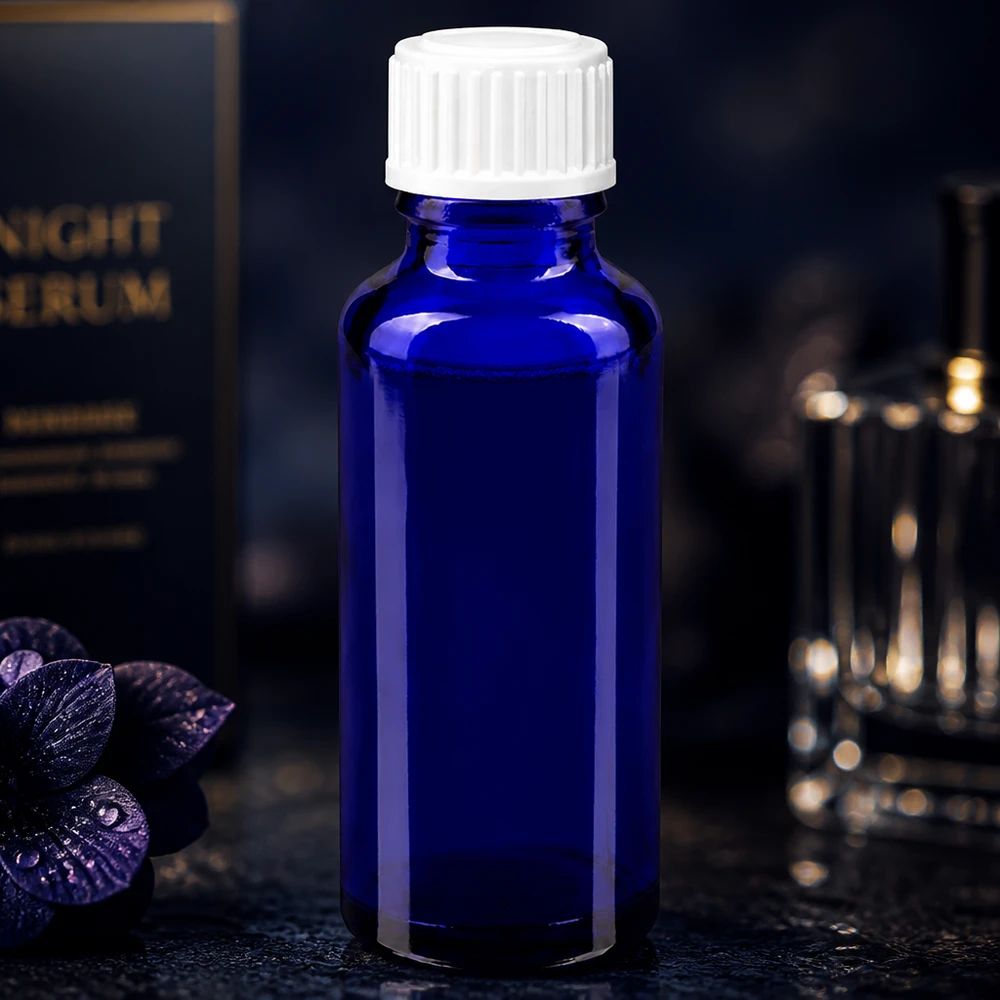 Smukła buteleczka ze szkła kobaltowego o pojemności 30 ml z białym zamknięciem zabezpieczającym w eleganckim opakowaniu serum na noc