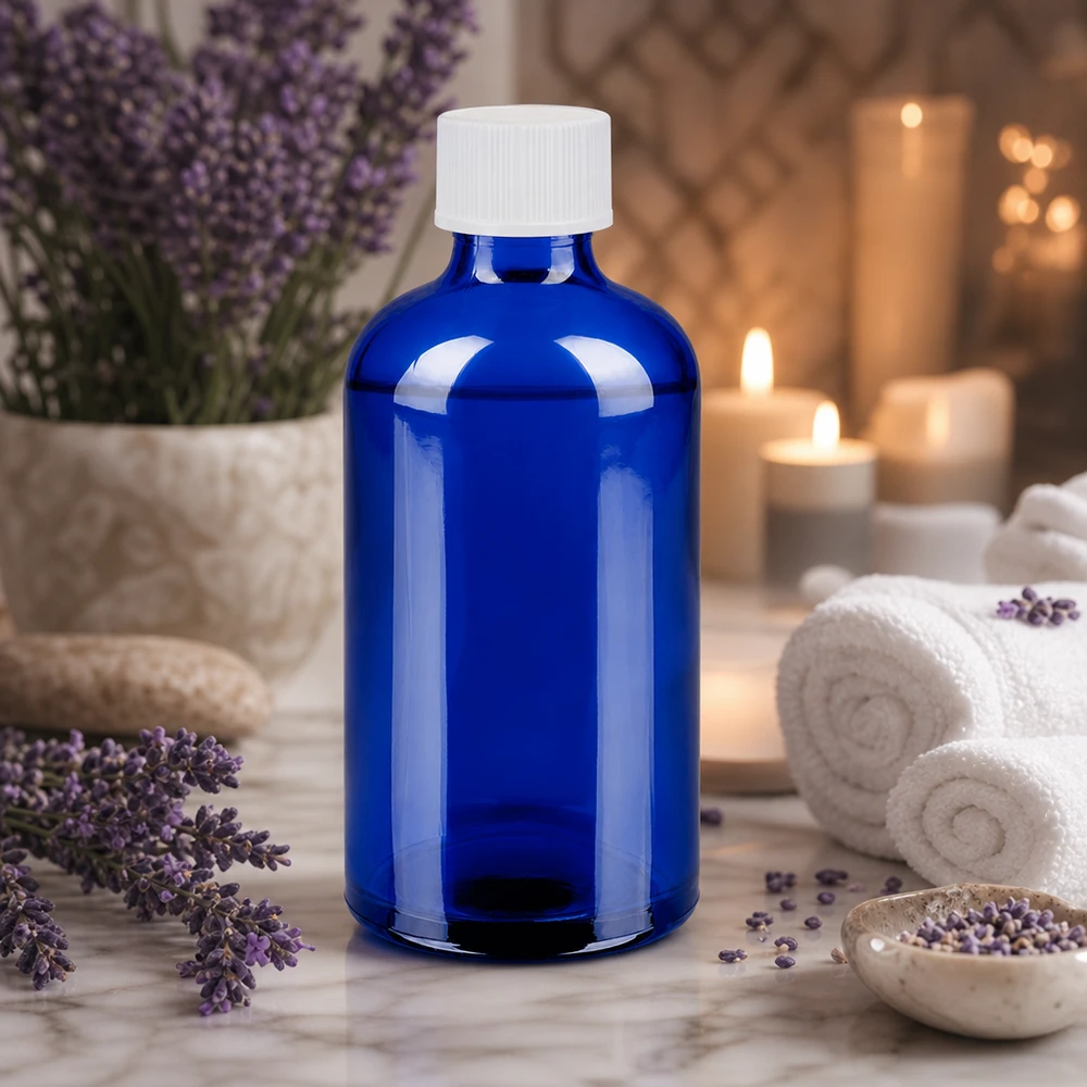 Elegancka niebieska szklana butelka 100 ml z białą nakrętką do zastosowań w aromaterapii i odnowie biologicznej