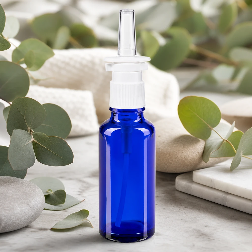 Butelka na spray do nosa o pojemności 30 ml w kolorze kobaltowym z białą głowicą pompującą i gałązkami eukaliptusa jako naturalną dekoracją