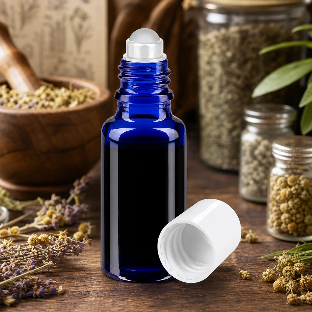 Butelka apteczna niebieska 20ml nakrętka roll-on biała 20 ml niebieska szklana buteleczka apteczna z kulką i białą zakrętką, umieszczona między lawendą a ziołami