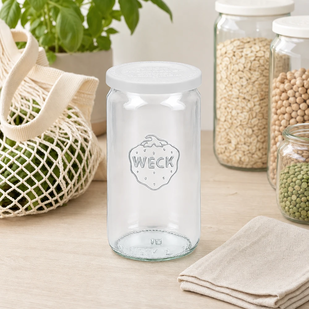 Słoik cylindryczny WECK 340 ml pusty z pokrywką RR60 w kuchni skandynawskiej między słoikami do przechowywania a torbą siatkową