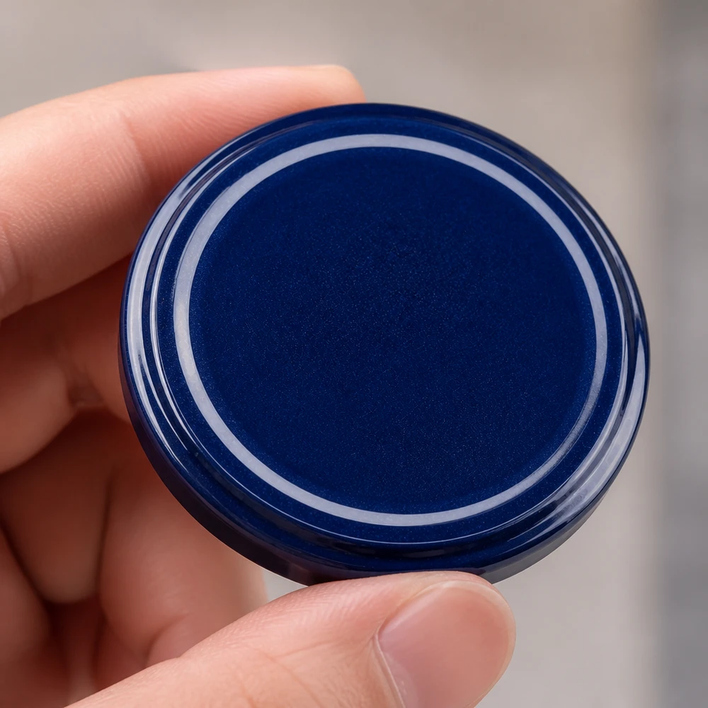 Zbliżenie na niebieską pokrywkę TO82 82 mm BasicSeal – górna strona z błyszczącą powierzchnią z tworzywa sztucznego UNiTWIST