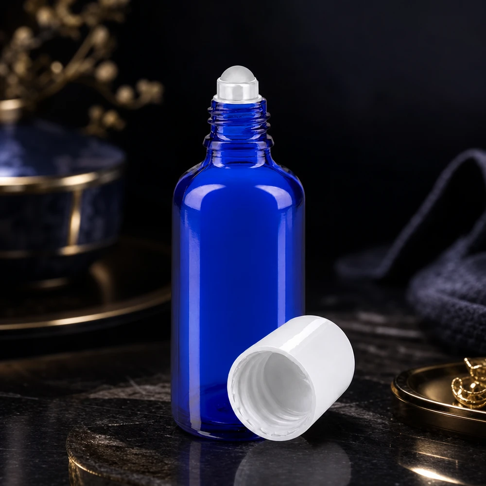 Otwarty niebieski szklany flakon apteczny o pojemności 50 ml z białą nakładką z kulką na ciemnej marmurowej powierzchni