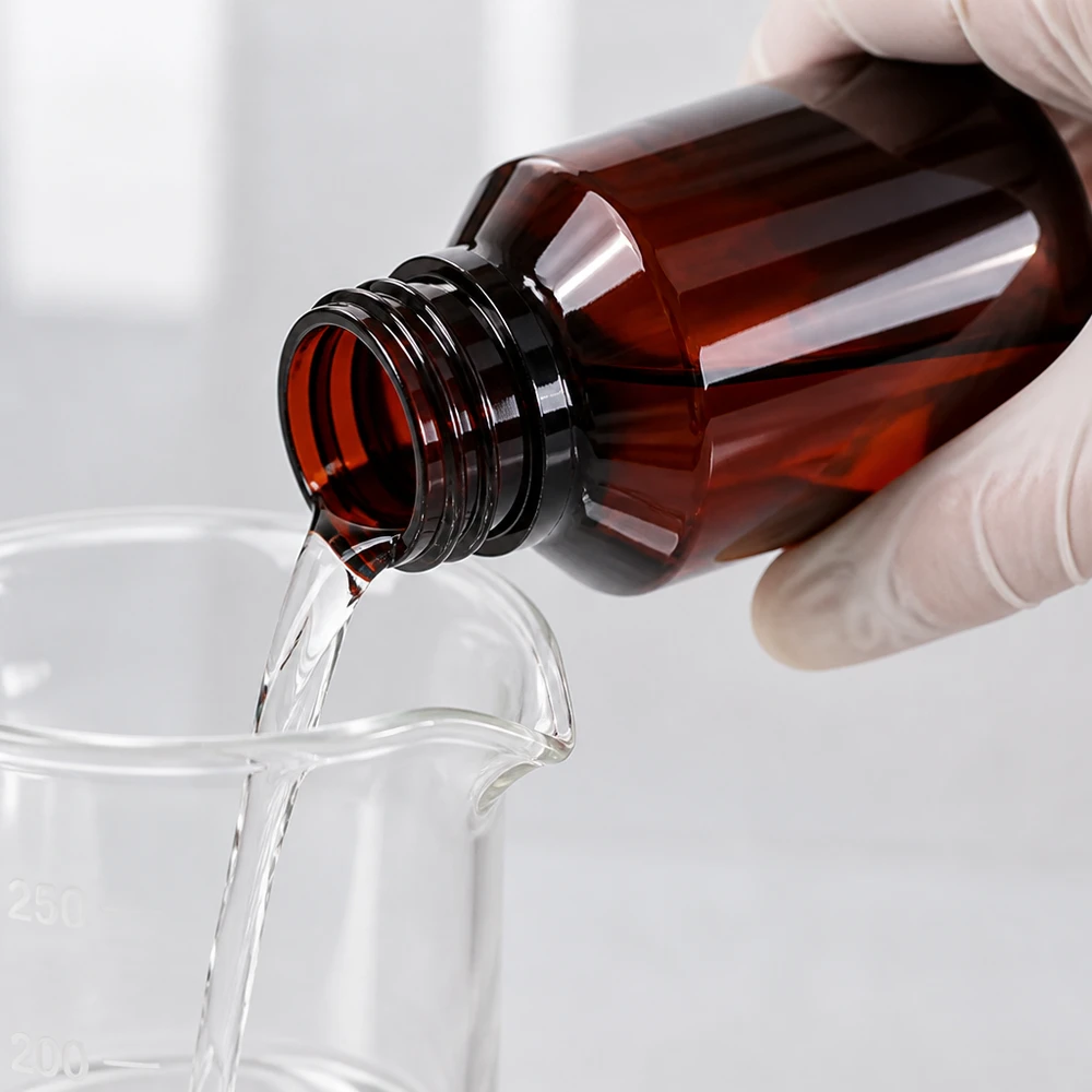 Butelka PET 100ml z pompką dozującą biała Chemikalienbeständige PET Flasche 100ml bernsteinfarben mit weisser Dispenserpumpe in Laborumgebung