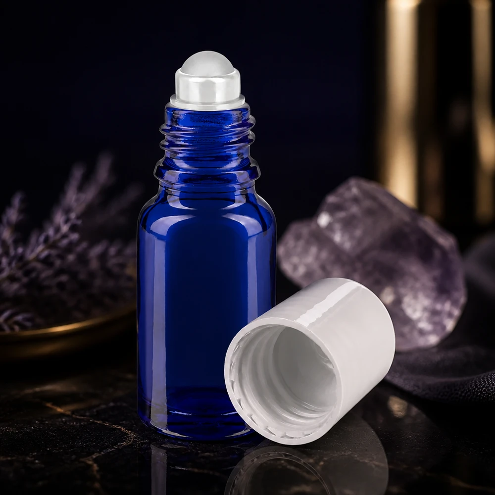Butelka apteczna niebieska 10ml nakrętka roll-on biała Szklana buteleczka o pojemności 10 ml w kolorze kobaltowym z białą zakrętką i przezroczystą kulką na czarnym tle