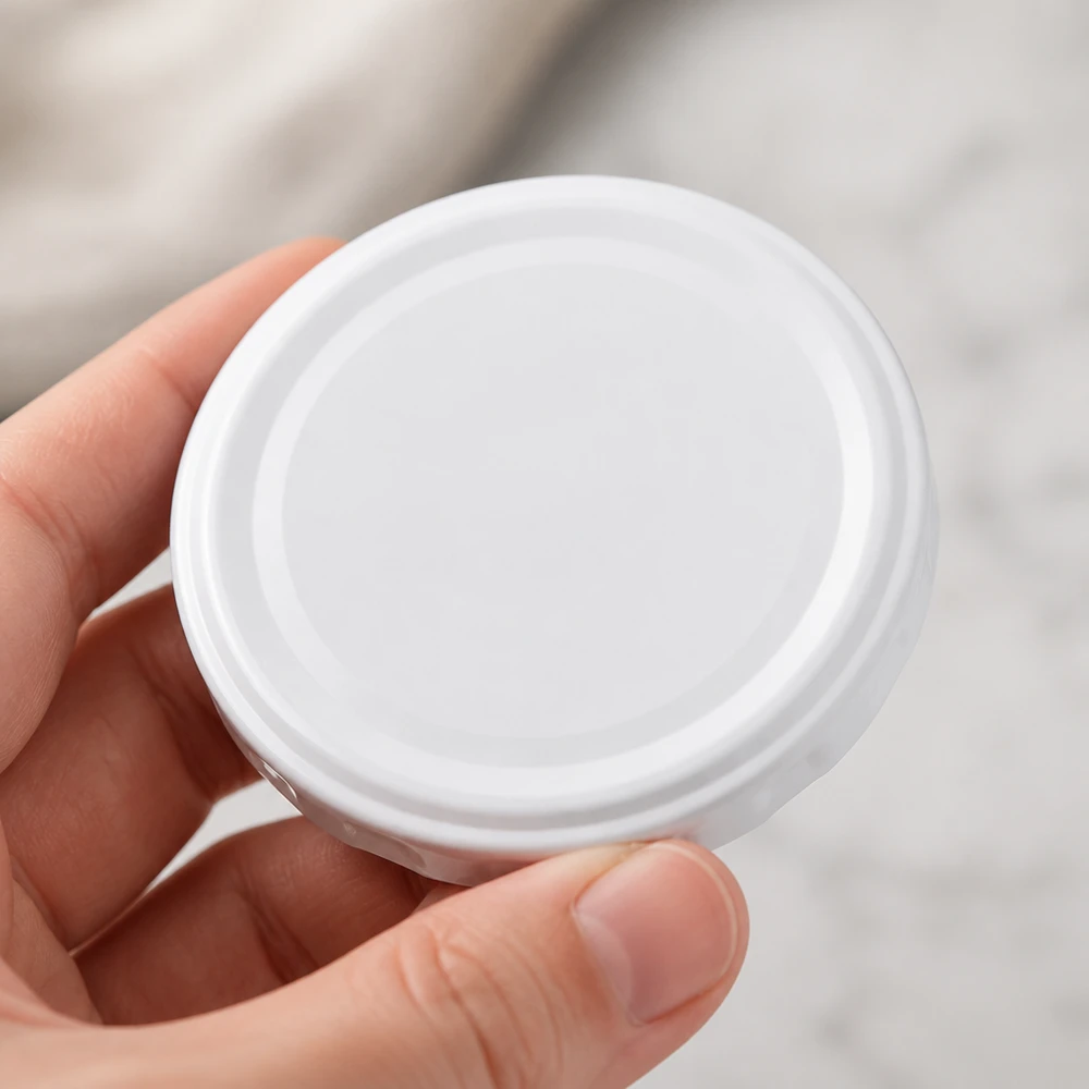 Widok z góry na białą pokrywkę TO58deep 58 mm BasicSeal UNiTWIST – okrągły kształt, jednolita powierzchnia