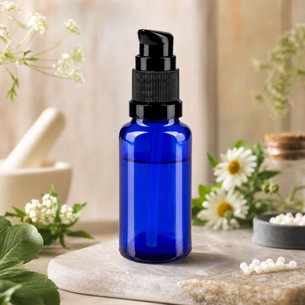 Butelka z pompką o pojemności 20 ml, wykonana z kobaltowo-niebieskiego szkła ochronnego, z czarną głowicą pompki osadzoną na kamieniu naturalnym