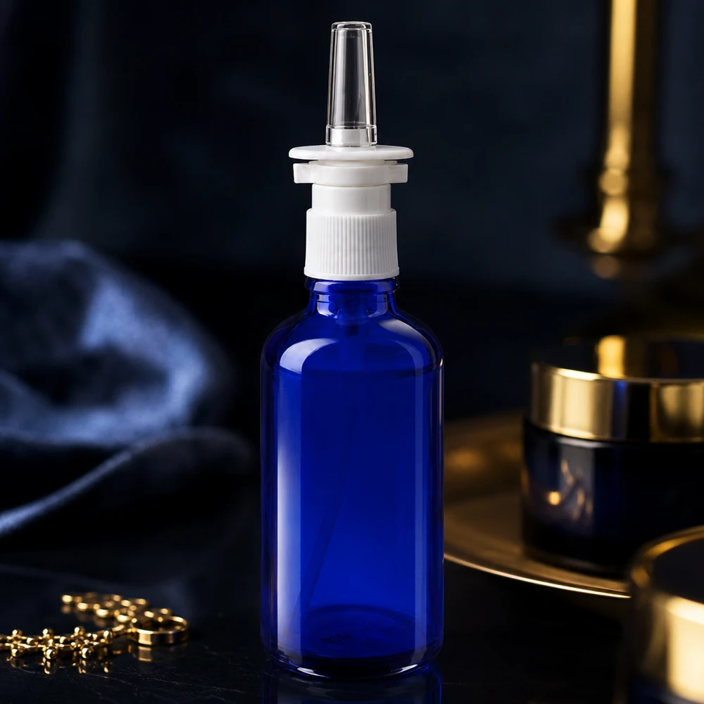 Butelka apteczna niebieska 50ml atomizer do nosa biały St Butelka z aerozolem do nosa o pojemności 50 ml, wykonana z niebieskiego szkła aptecznego, z białą nakrętką i przezroczystą dyszą do nosa