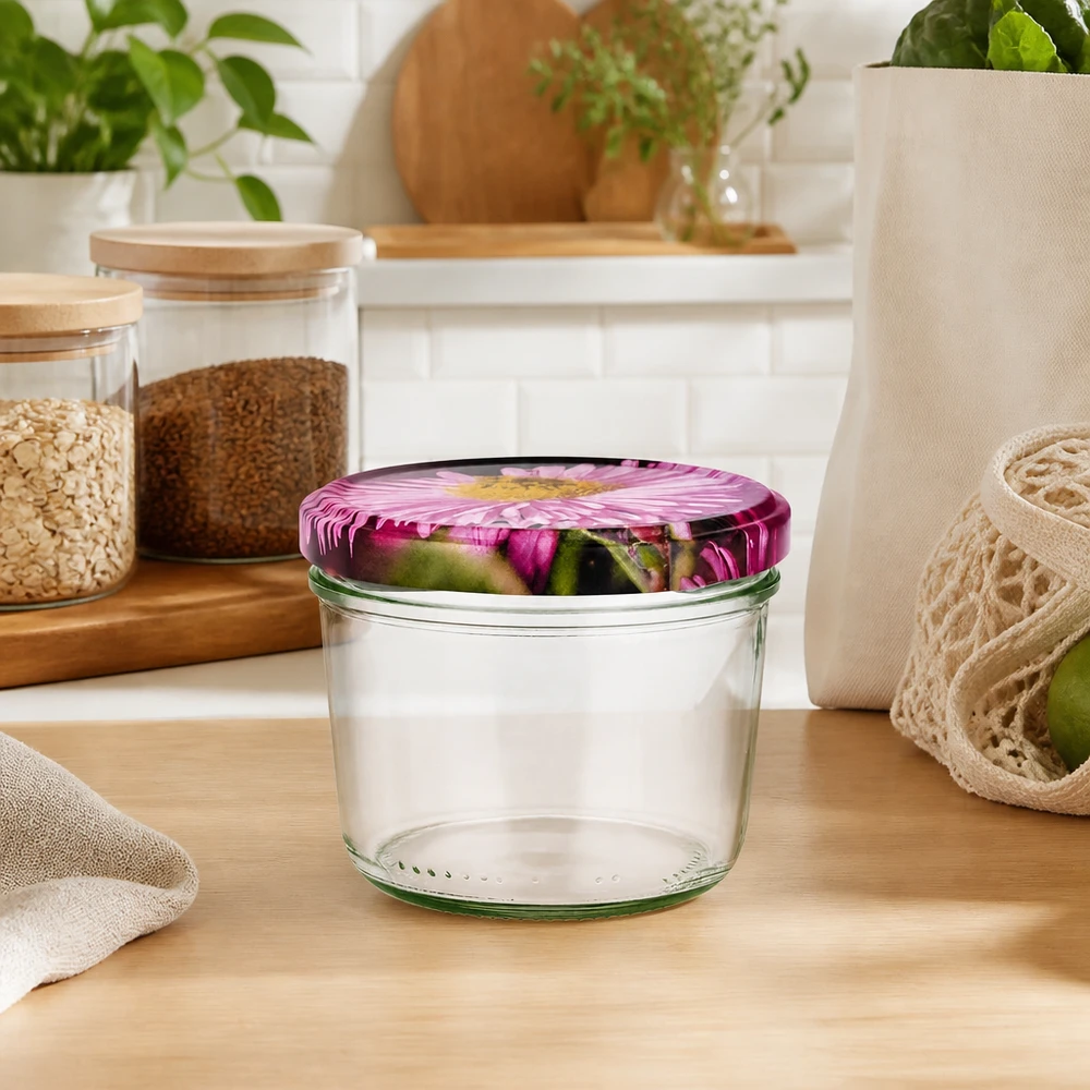 230 ml szklanka z pokrywką BasicSeal dekor kwiatowy UN Sturzglas 230ml leer mit rosa Blütendeckel in natürlicher Küchenumgebung, umgeben von Vorratsgläsern und Pflanzen