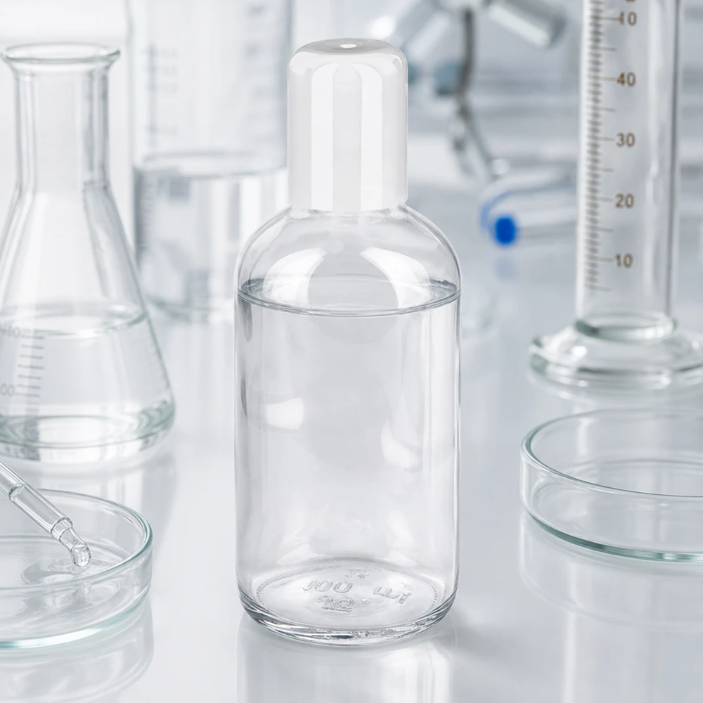 Butelka roll-on 100 ml biała STD ClearLine UT18/100 Butelka z kulką o pojemności 100 ml ClearLine UT18/100 w środowisku laboratoryjnym z cylindrem miarowym i kolbą Erlenmeyera