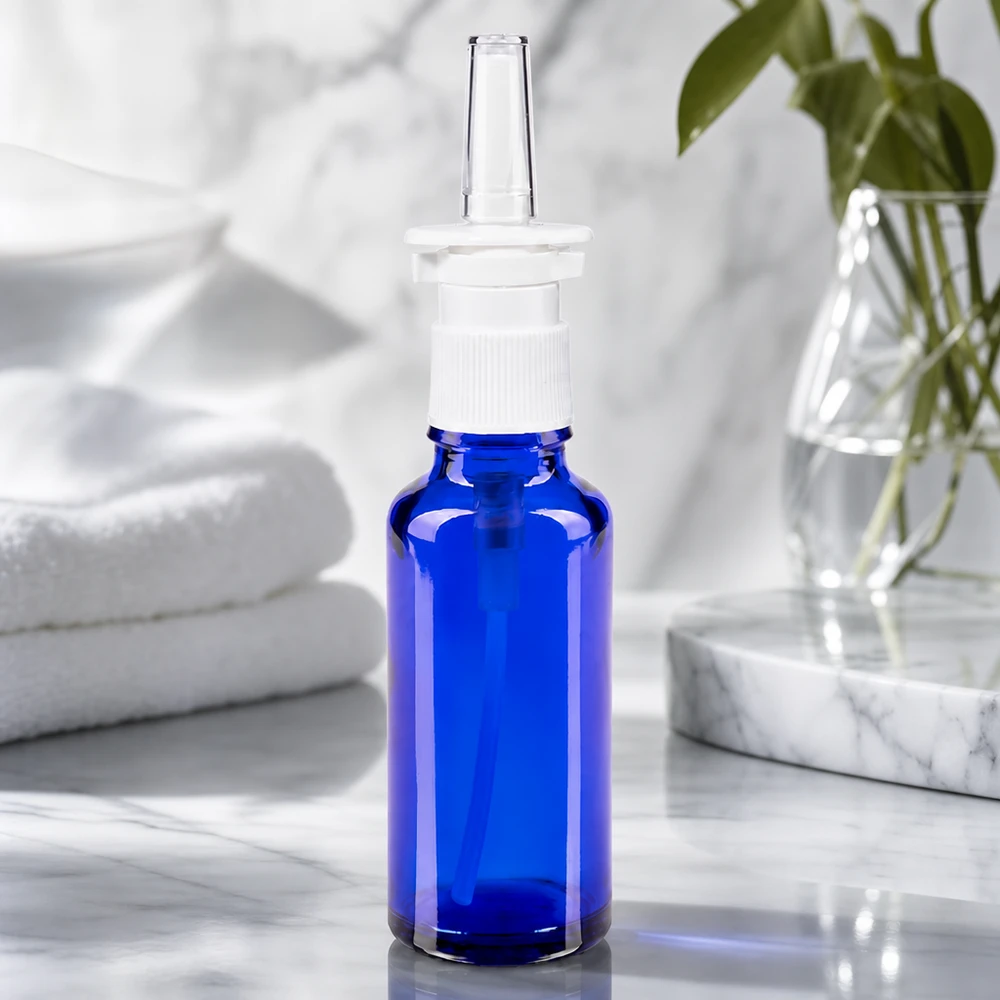Butelka na spray do nosa o pojemności 30 ml, wykonana z kobaltowo-niebieskiego szkła, z białą głowicą pompującą, przeznaczona do zastosowań farmaceutycznych