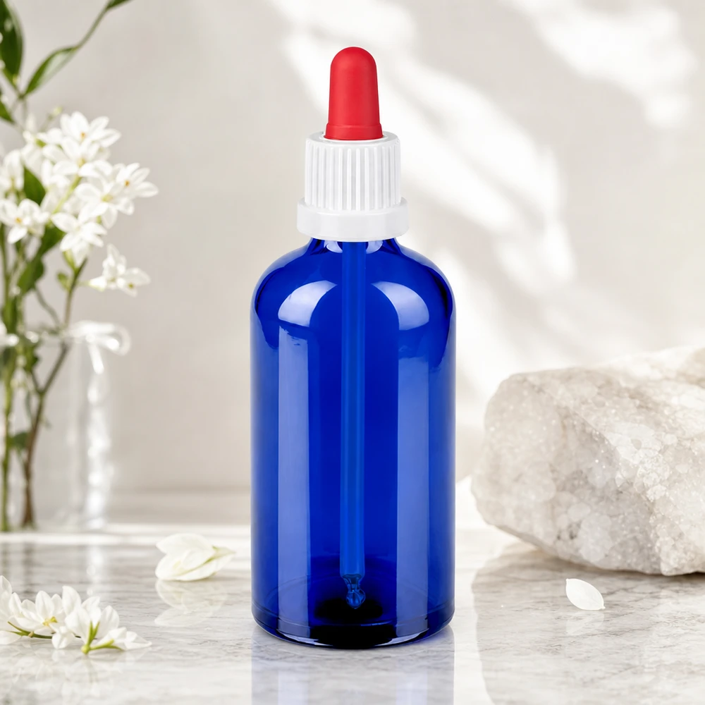 Elegancka niebieska szklana butelka 100 ml z białą zakrętką i czerwoną pipetą do olejków eterycznych