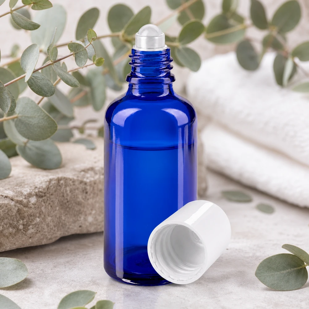 Butelka apteczna niebieska 50ml nakrętka roll-on biała Niebieska szklana butelka apteczna z rolką o pojemności 50 ml, z aplikatorem z kulką ze stali nierdzewnej i otwartą białą pokrywką