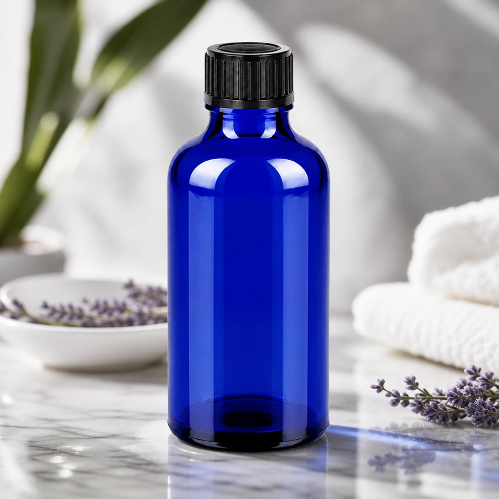 Butelka farmaceutyczna o pojemności 50 ml wykonana z chroniącego przed promieniowaniem UV niebieskiego szkła kobaltowego z czarną zakrętką umożliwiającą łatwe manipulowanie.