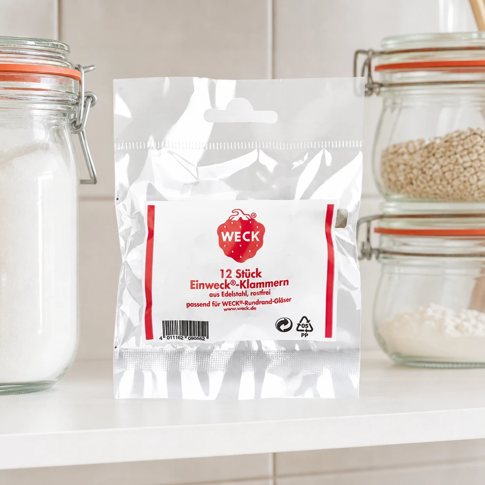 WECK zaciska opakowania produktów w kuchni między słoikami z mąką zbożową na białym blacie kuchennym