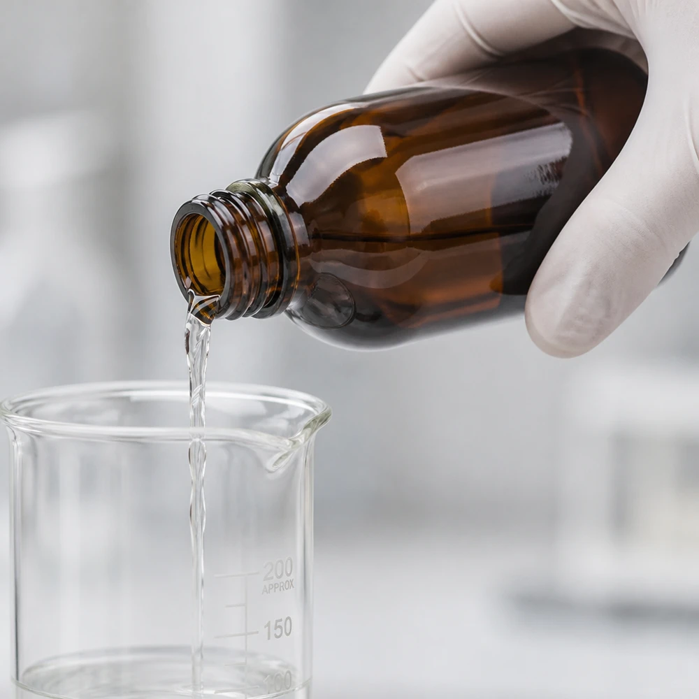 Präzises Dosieren klarer Flüssigkeit aus brauner Flasche in skalierten Glasbecher