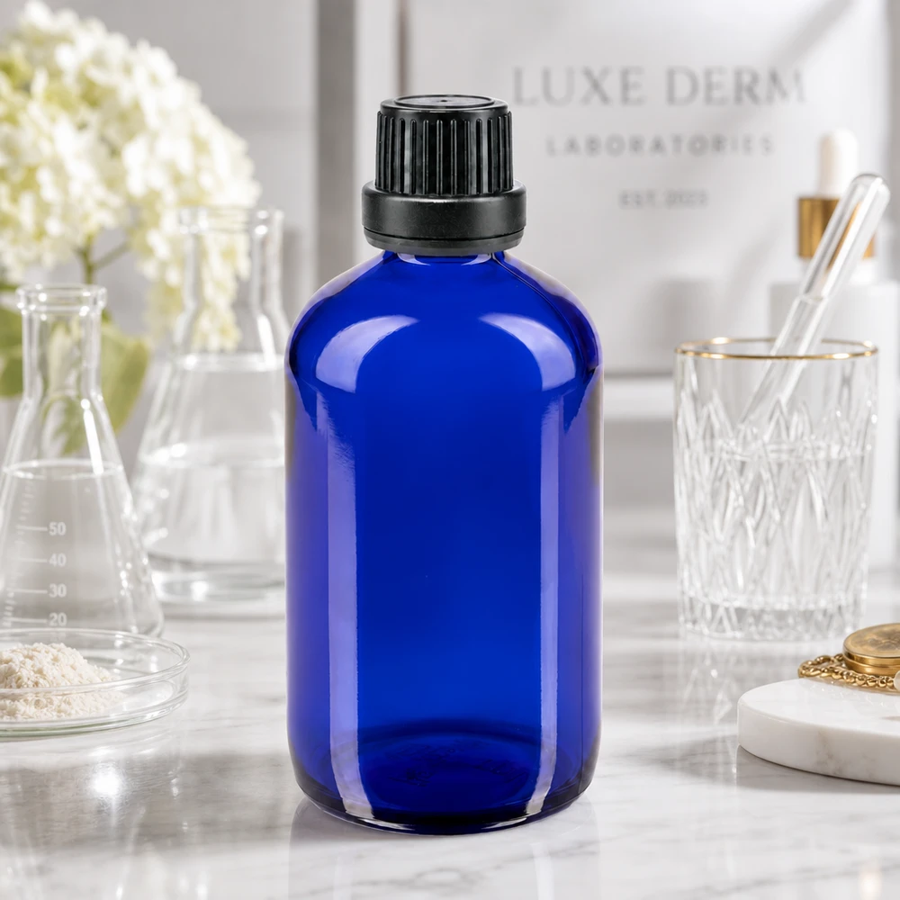 Niebieska szklana butelka o pojemności 100 ml z czarnym zamknięciem zabezpieczającym na tle logo Luxe Derm Laboratorien