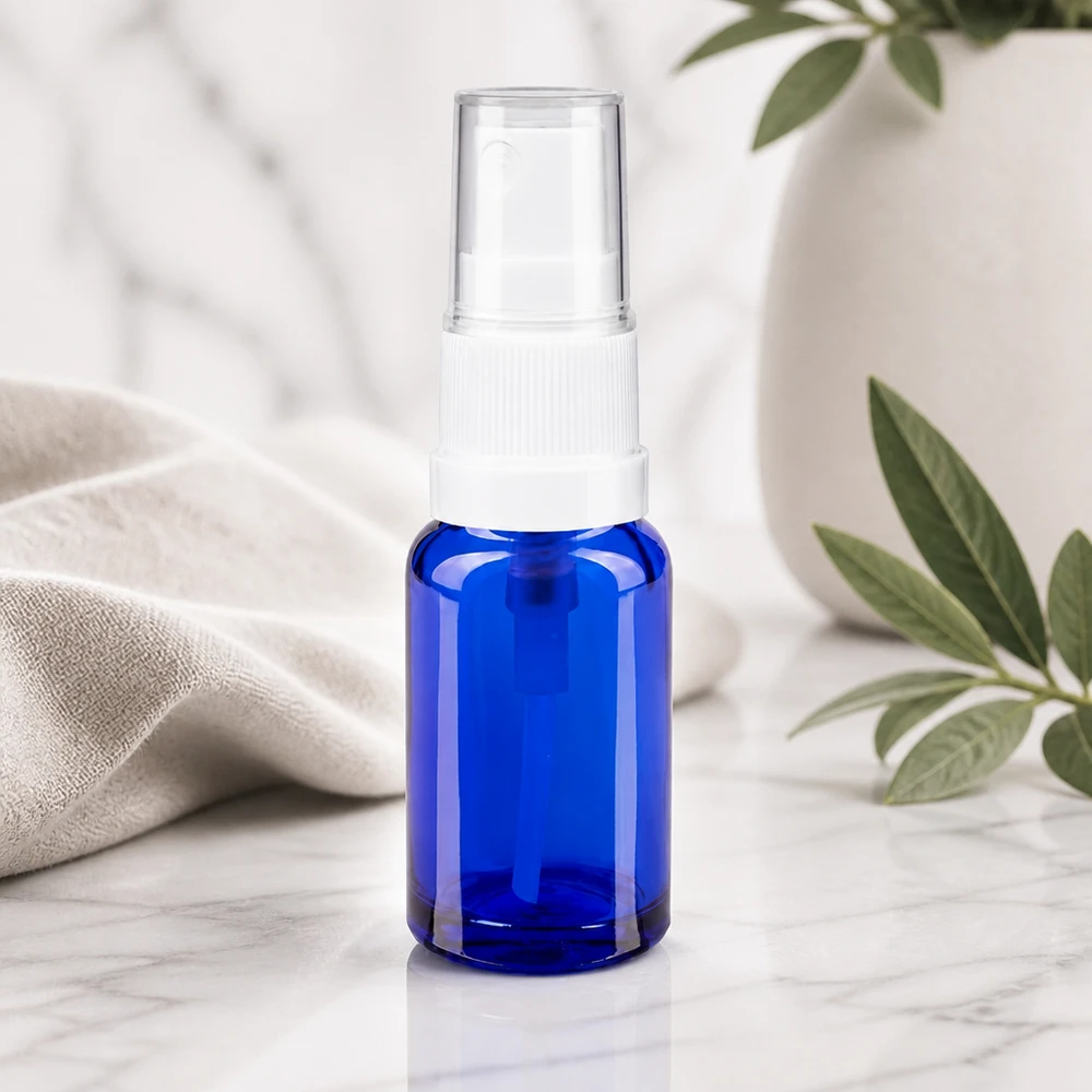 Butelka apteczna niebieska 10ml spray top biały Niebieska szklana buteleczka apteczna o pojemności 10 ml z białym standardowym rozpylaczem i przezroczystą nasadką ochronną